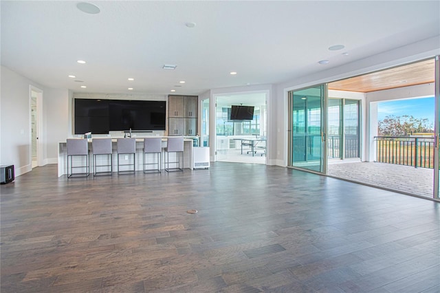 unfurnished living room featuring visible vents, recessed lighting, dark wood-style flooring, and baseboards