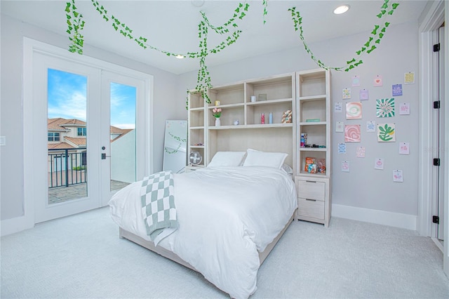 carpeted bedroom featuring baseboards, recessed lighting, freestanding refrigerator, french doors, and access to outside