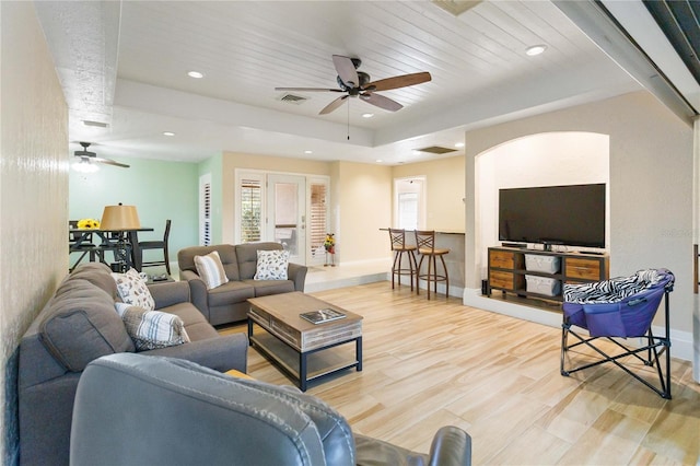 living room with light wood-type flooring, ceiling fan, and wood ceiling