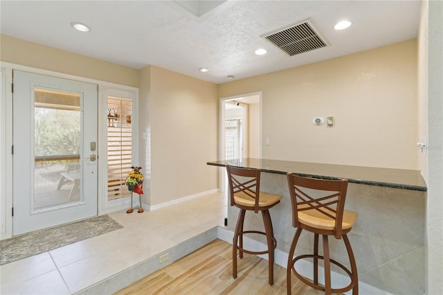 kitchen with a textured ceiling and a breakfast bar area