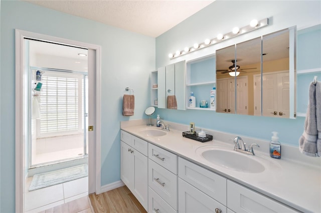 bathroom featuring ceiling fan, vanity, wood-type flooring, and a textured ceiling