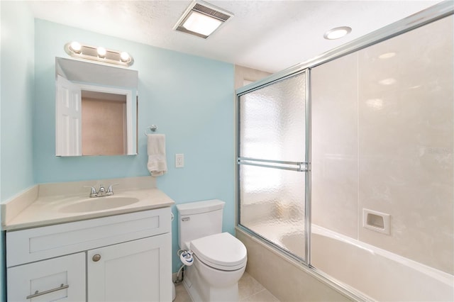 full bathroom with tile patterned flooring, combined bath / shower with glass door, a textured ceiling, toilet, and vanity