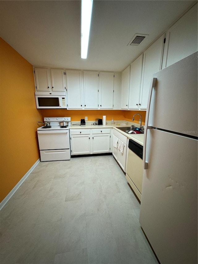 kitchen featuring sink, white cabinets, and white appliances