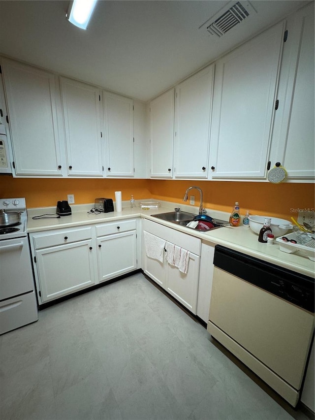 kitchen featuring sink, white cabinets, and white appliances