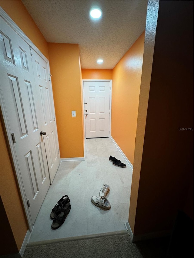 hallway with a textured ceiling