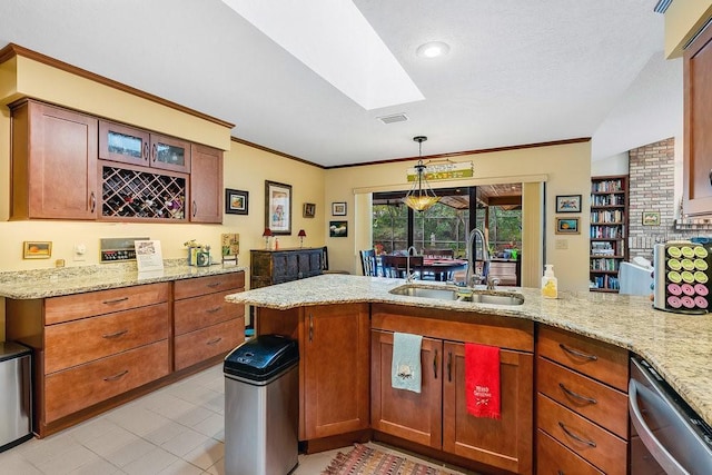 kitchen featuring dishwasher, sink, light stone counters, kitchen peninsula, and decorative light fixtures