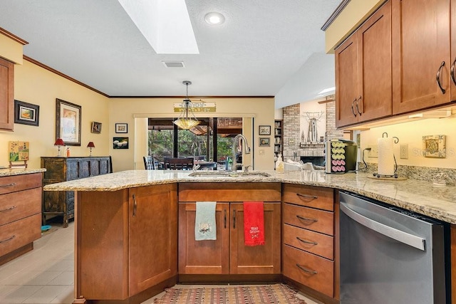 kitchen with kitchen peninsula, light stone counters, vaulted ceiling with skylight, sink, and dishwasher