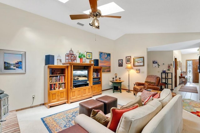 carpeted living room featuring ceiling fan and vaulted ceiling with skylight