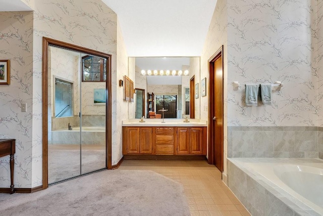 bathroom featuring vanity and tiled bath