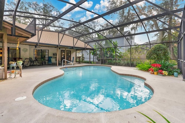 view of swimming pool with ceiling fan, a lanai, and a patio