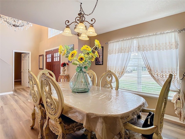 dining room with a healthy amount of sunlight, light hardwood / wood-style flooring, and an inviting chandelier