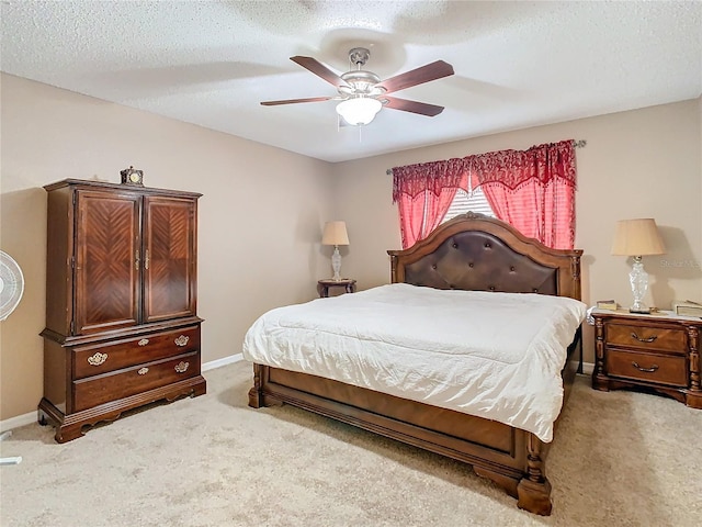 carpeted bedroom with ceiling fan and a textured ceiling