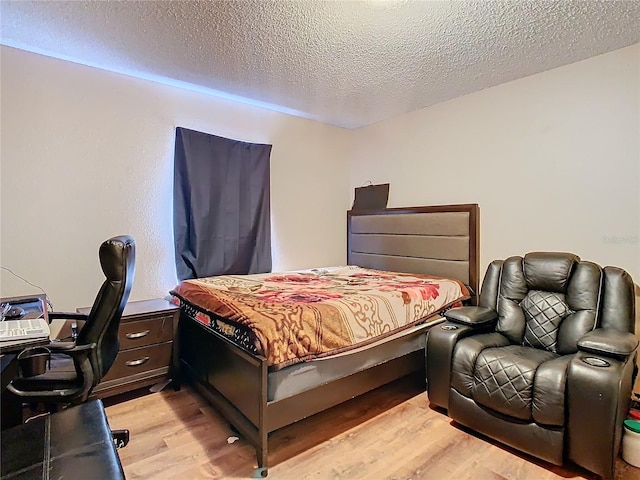 bedroom with a textured ceiling and light hardwood / wood-style flooring