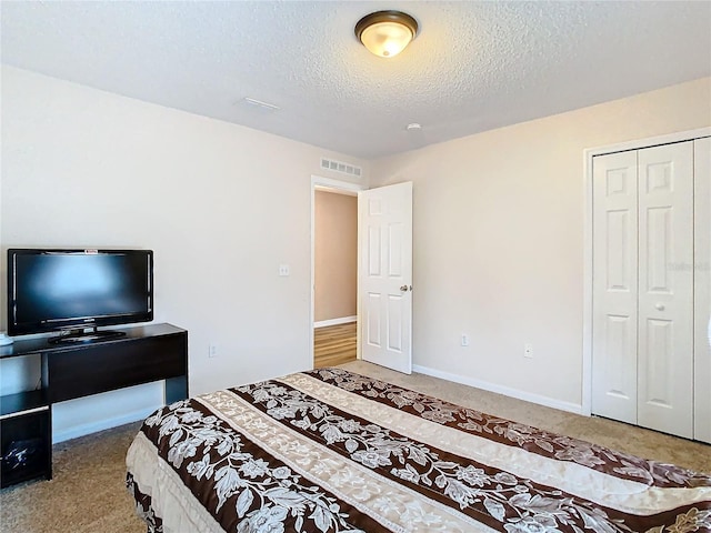 bedroom with carpet floors, a textured ceiling, and a closet