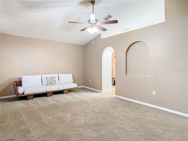 unfurnished room with a textured ceiling, ceiling fan, light carpet, and lofted ceiling