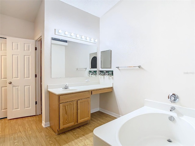 bathroom featuring a tub, hardwood / wood-style floors, and vanity