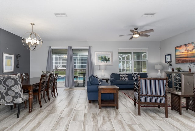 living room with ceiling fan with notable chandelier