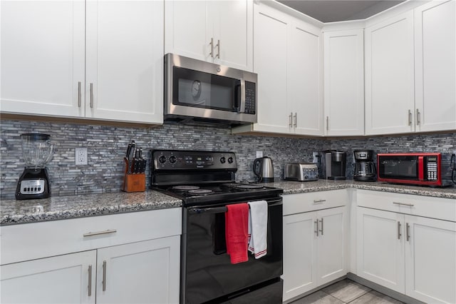 kitchen featuring light stone countertops, backsplash, black appliances, light tile patterned floors, and white cabinets