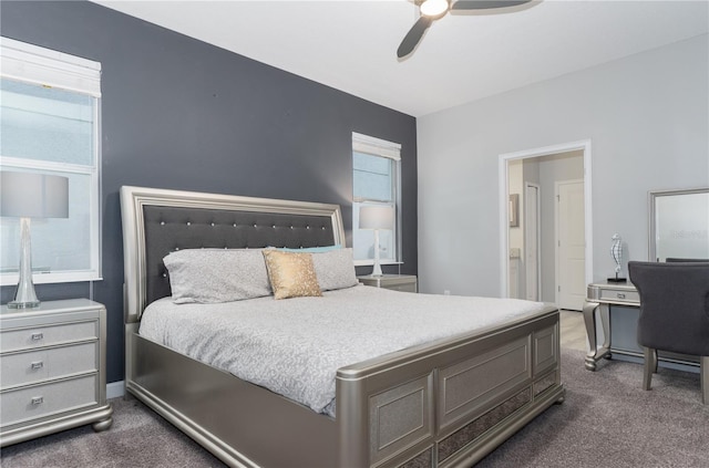 bedroom with connected bathroom, dark carpet, and ceiling fan