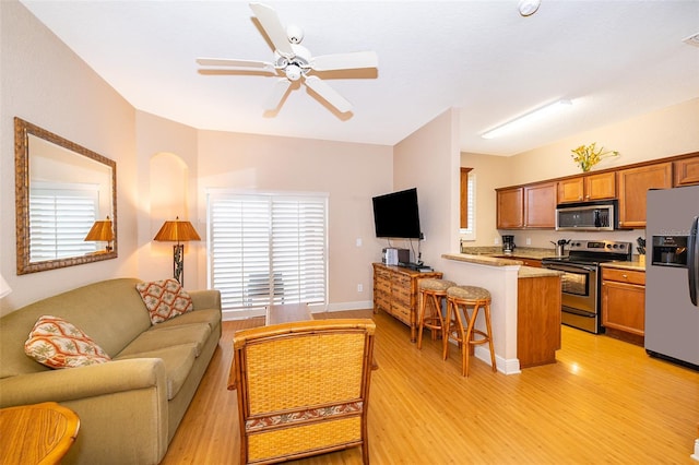 living room featuring ceiling fan and light hardwood / wood-style flooring