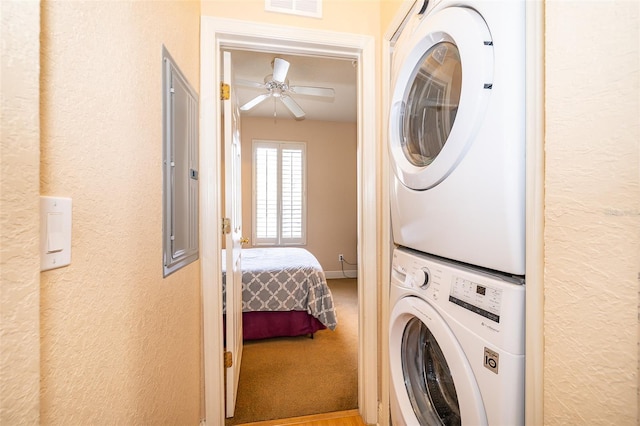 washroom featuring ceiling fan and stacked washer and clothes dryer