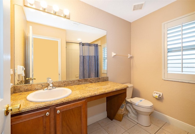 bathroom with tile patterned floors, curtained shower, vanity, and toilet