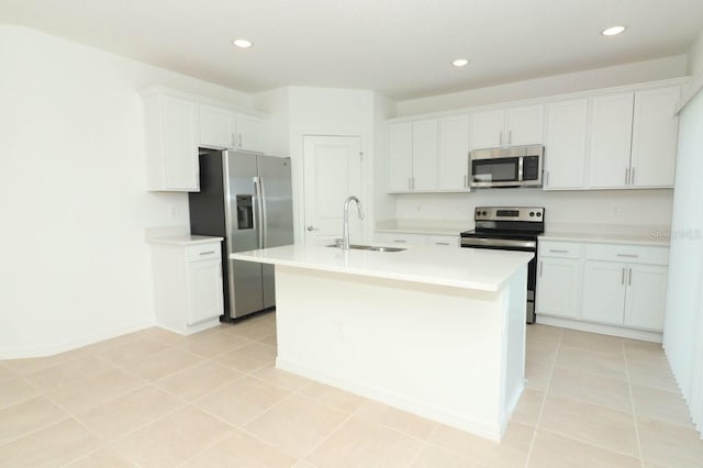 kitchen with white cabinets, sink, stainless steel appliances, and an island with sink