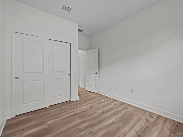 unfurnished bedroom with light hardwood / wood-style flooring and a closet