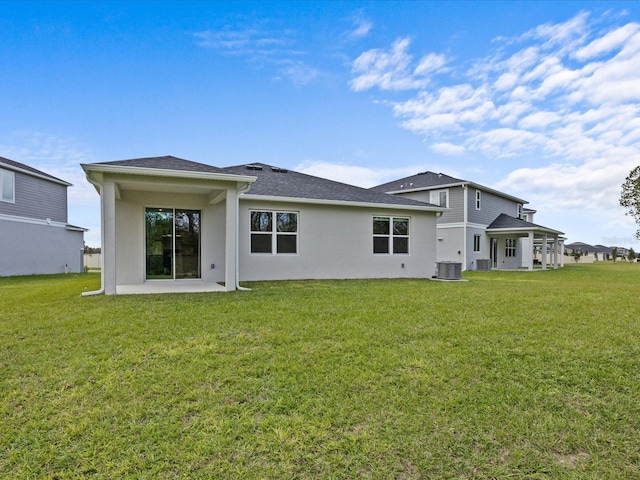 rear view of property featuring a lawn, a patio, and central AC