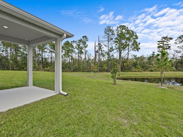 view of yard with a water view and a patio