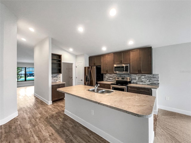 kitchen featuring dark brown cabinetry, sink, stainless steel appliances, an island with sink, and lofted ceiling