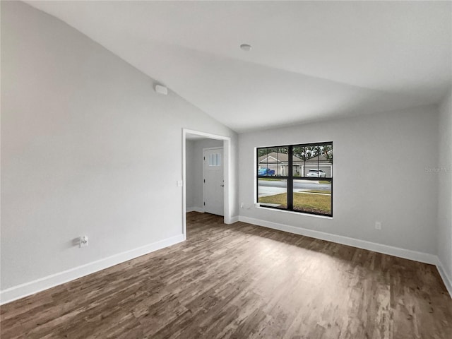 empty room with hardwood / wood-style floors and lofted ceiling