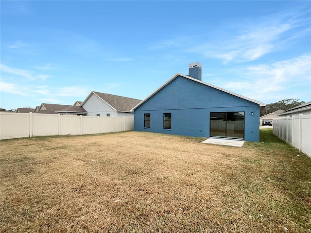 back of house with a lawn