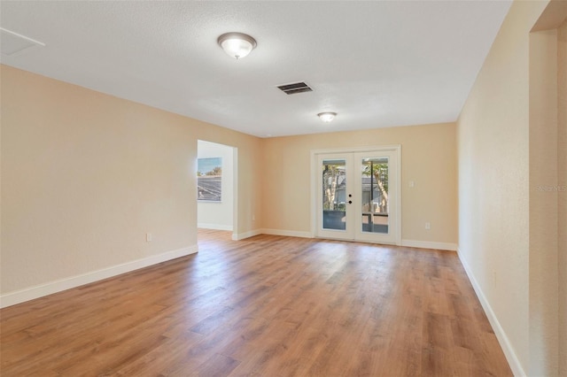 unfurnished room with french doors and hardwood / wood-style floors