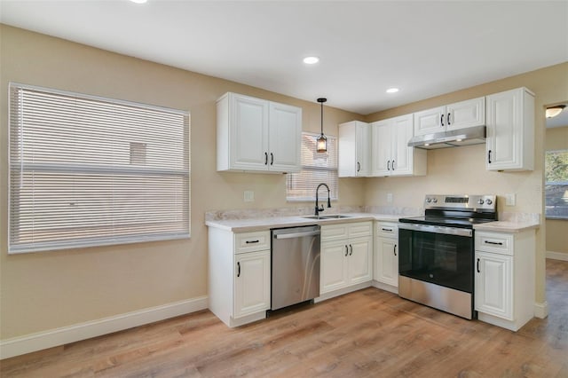 kitchen with pendant lighting, white cabinetry, appliances with stainless steel finishes, and light hardwood / wood-style flooring