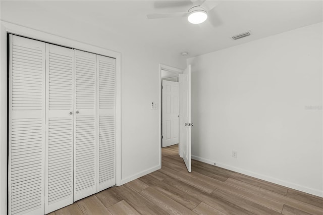 unfurnished bedroom featuring ceiling fan, a closet, and light hardwood / wood-style floors