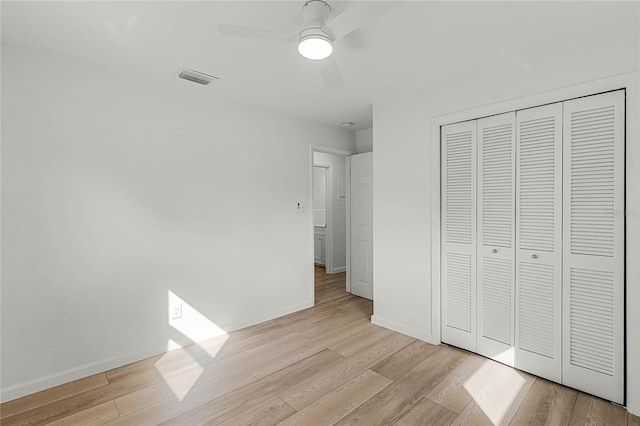 unfurnished bedroom featuring light wood-type flooring, a closet, and ceiling fan