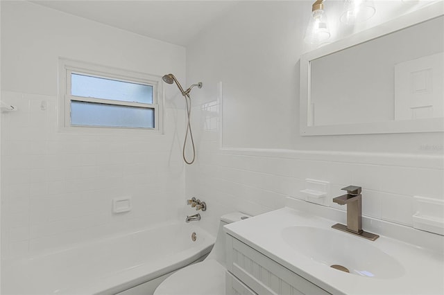 full bathroom with tiled shower / bath combo, toilet, tile walls, and vanity