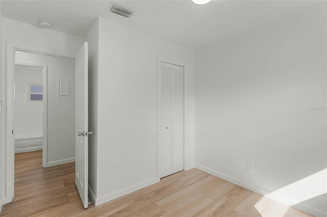 unfurnished bedroom featuring light hardwood / wood-style flooring and a closet