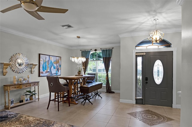 foyer with ornamental molding, ceiling fan with notable chandelier, and light tile patterned floors