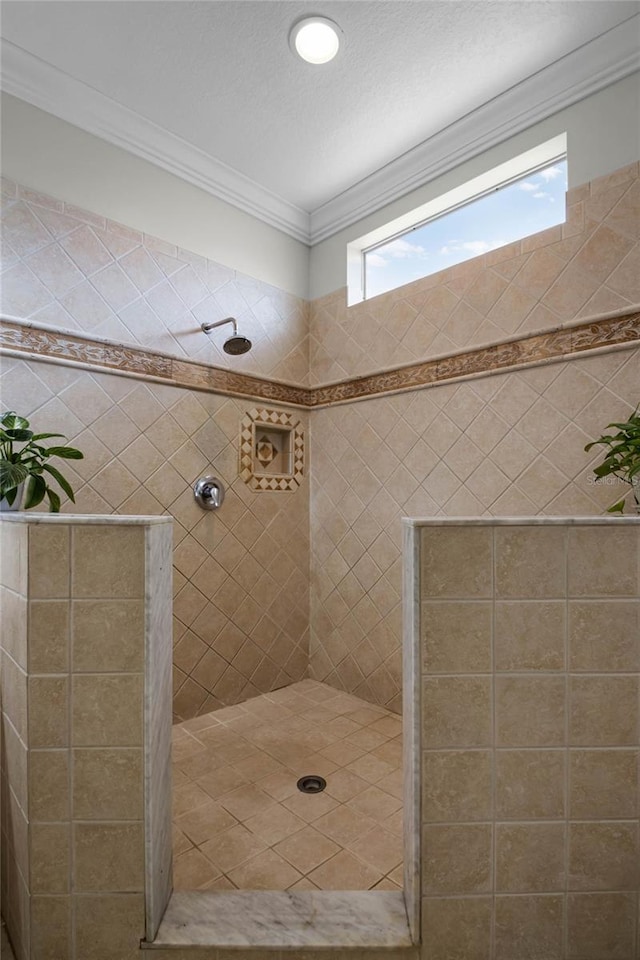 bathroom with crown molding and a tile shower