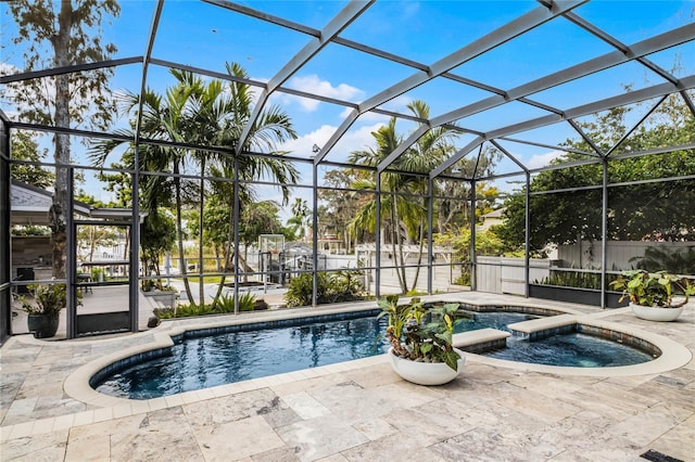 view of pool featuring a lanai, an in ground hot tub, and a patio area