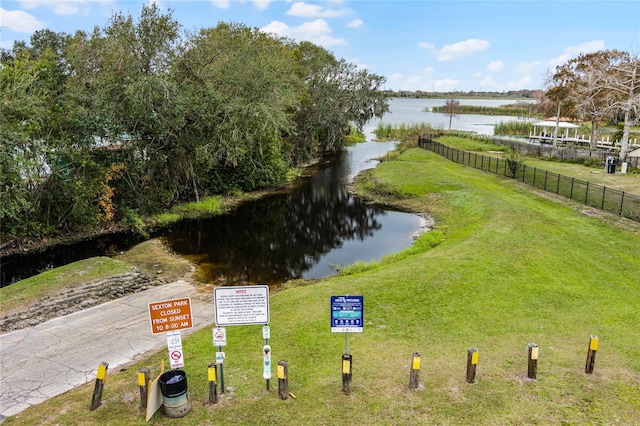 view of yard with a water view and fence