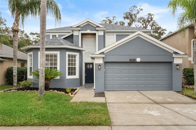 view of property with a garage and a front lawn