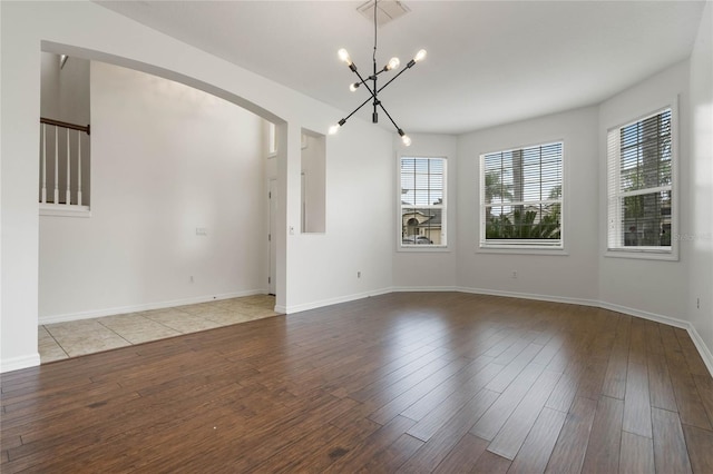 spare room with an inviting chandelier and light hardwood / wood-style flooring