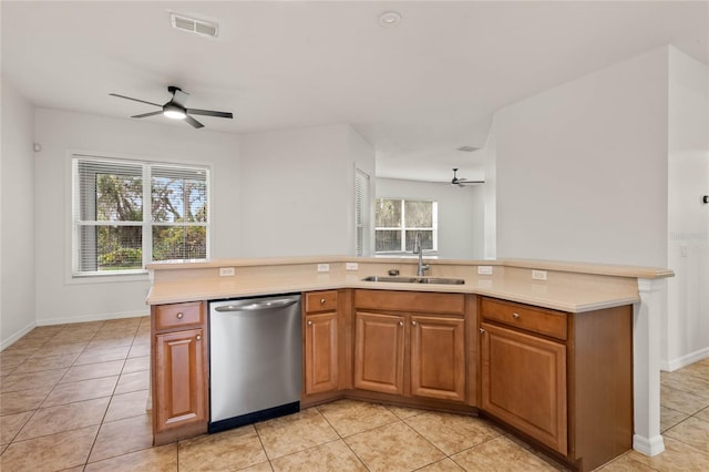 kitchen featuring kitchen peninsula, dishwasher, light tile patterned floors, and sink