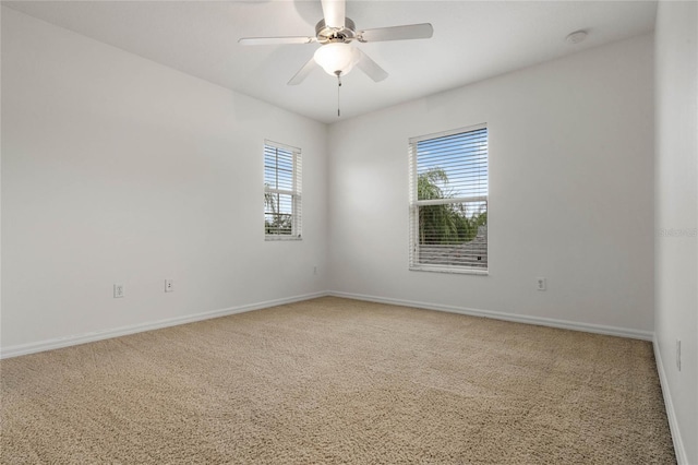 unfurnished room featuring carpet flooring, a wealth of natural light, and ceiling fan