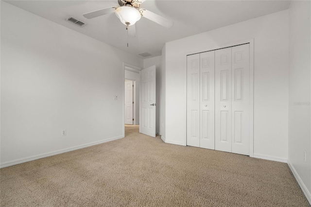 unfurnished bedroom featuring ceiling fan, a closet, and light carpet