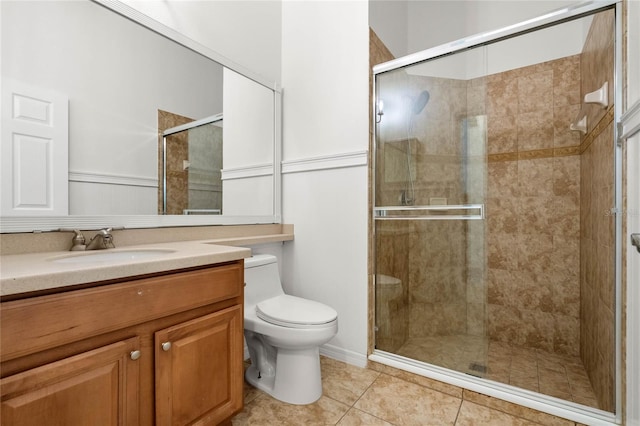 bathroom featuring tile patterned floors, vanity, toilet, and a shower with shower door