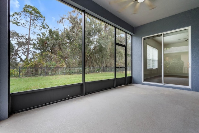 unfurnished sunroom with ceiling fan and plenty of natural light